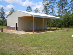 A barn with a metal roof in the middle of a field.