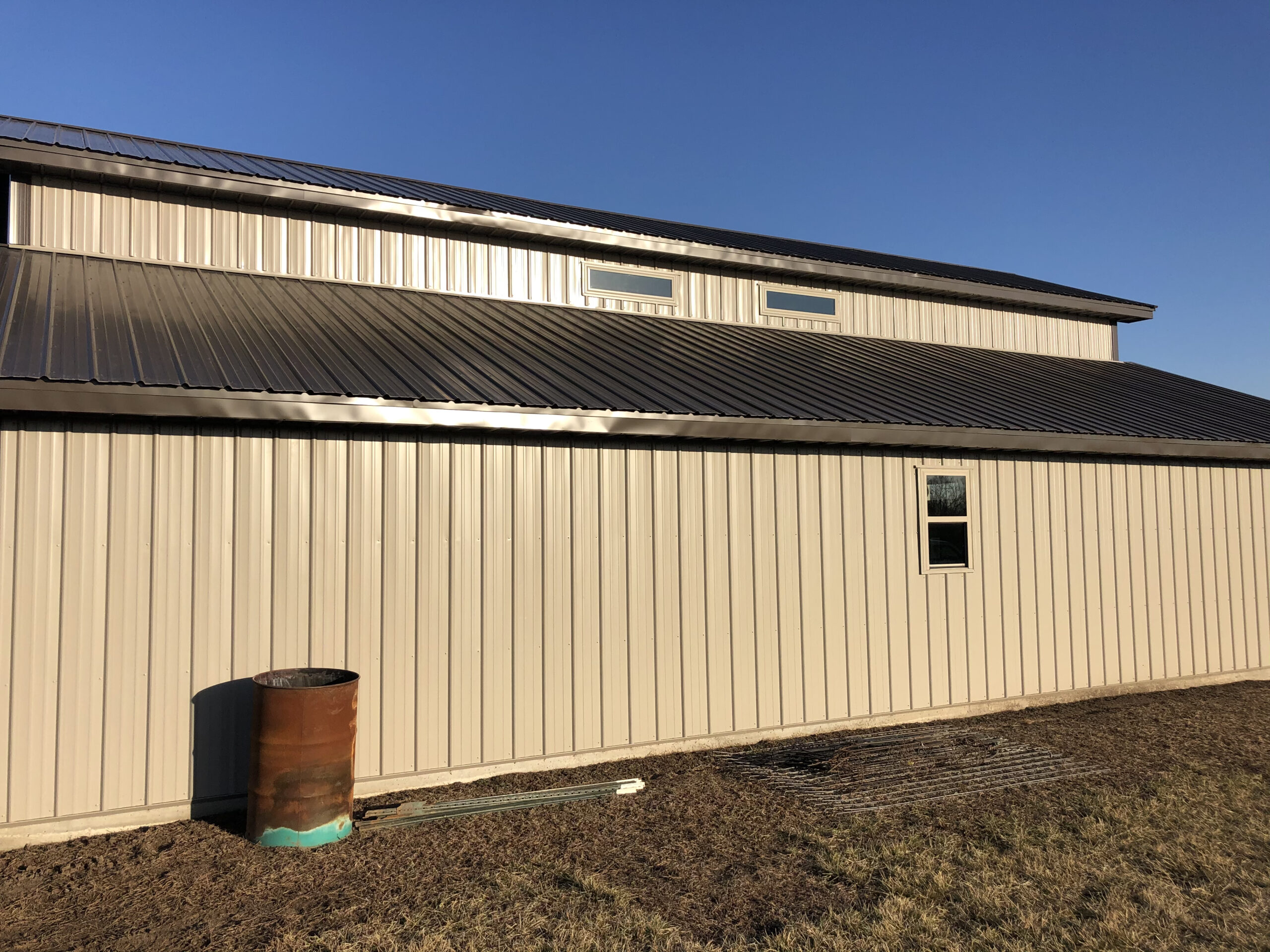 A modern farmhouse with a metal roof and metal siding.