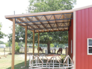 A red barn with a red roof and a horse stall.