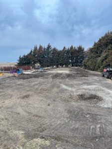A dirt field with a dirt road in the background.