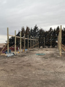 The construction of a barn in the middle of a field.