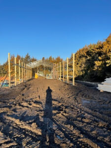 A man is standing in front of a building under construction.