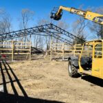 A yellow bulldozer is working on a wooden structure.