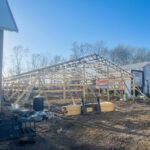 A barn under construction with a wooden frame.