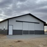 A barn with a white roof and black siding.