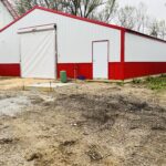 A red and white barn with a door.