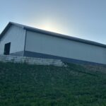 A white barn sitting on top of a hill.
