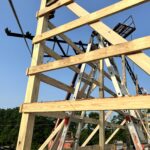 A wooden structure is being built in the middle of a field.