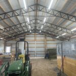 The inside of a barn with a tractor in it.